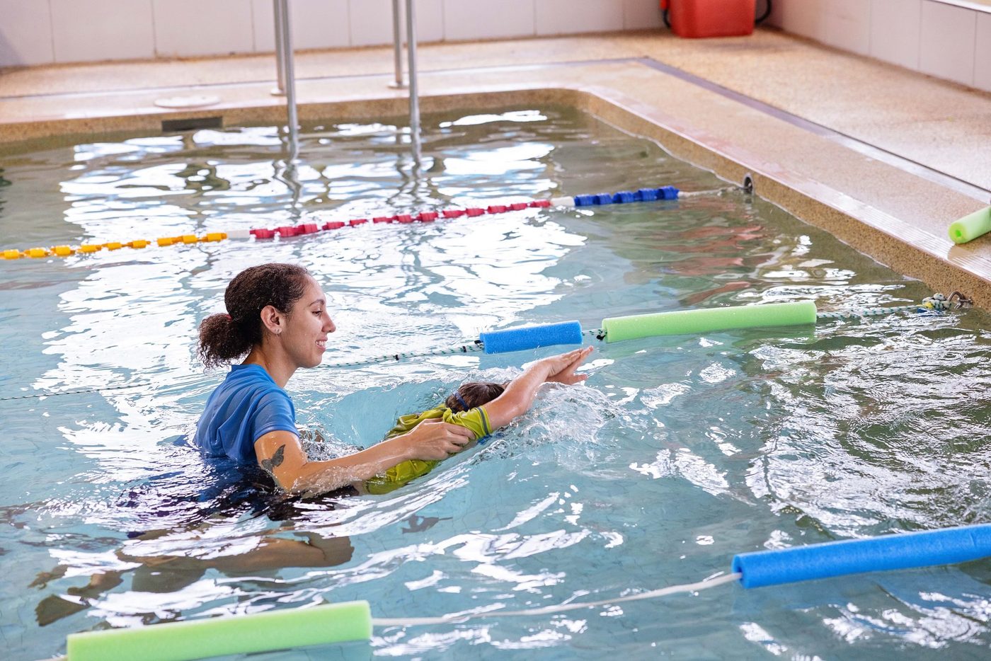 Children sitting poolside with their instructor