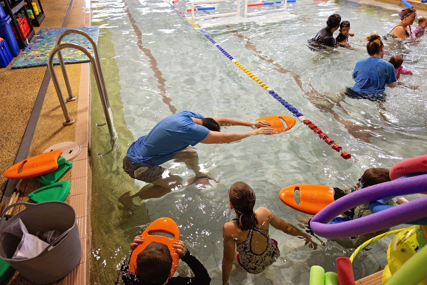Swim instructor guiding a child across the pool