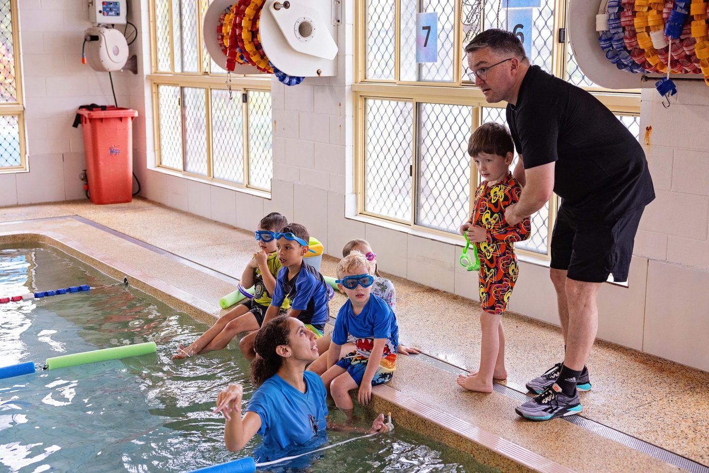 Instructor correcting a swimmer stroke